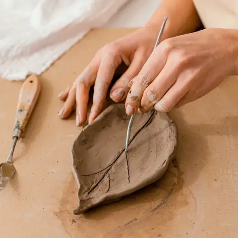 Create a functional ceramic item using traditional techniques such as pinching, coiling, or slab construction.